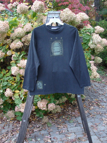 1997 Long Sleeved Tee Stone Door Cast Iron Size 1 displayed on a rack, showcasing drop shoulders, wider ribbed neckline, and a unique stone door theme paint, emphasizing its vintage and mid-weight organic cotton fabric.