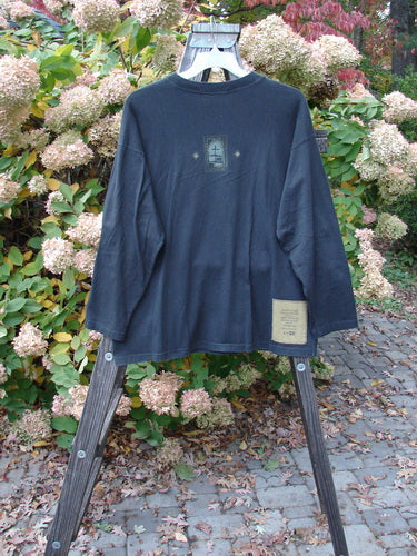1997 Long Sleeved Tee Stone Door Cast Iron Size 1, displayed on a rack, showcasing its wider ribbed neckline, drop shoulders, and unique painted stone door theme.