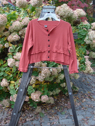 2000 Wool Pointelle Annu Jacket displayed on a wooden stand, showcasing its flared, slightly cropped shape with lettuce-edged accents and two front tiny rounded pockets.