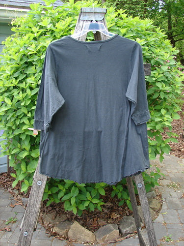 Barclay Banded Artist Pocket Top Metallic Kitty Kitty Black Size 1, displayed over a wooden ladder. Featuring a rounded neckline, double exterior diagonal pockets, three-quarter banded sleeves, and a widening A-line shape.