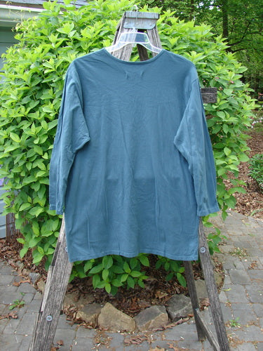 Barclay Long Sleeved Studio Tee Flower Garden Block Tealen Size 0, displayed on a step-ladder outdoors, showcases a straight boxy shape, thinner flattened neckline, and long sleeves.