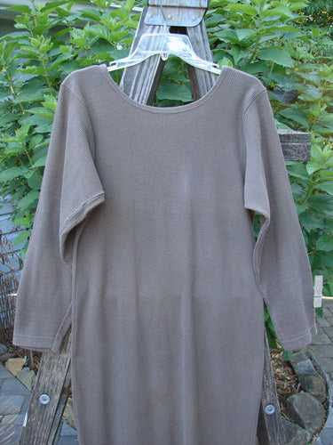 1991 Rib Thermal The Skinny Dress Unpainted Nut Brown Altered OSFA displayed hanging on a wooden fence, showcasing its long sleeves, rounded neckline, and textured cozy cotton thermal rib fabric.