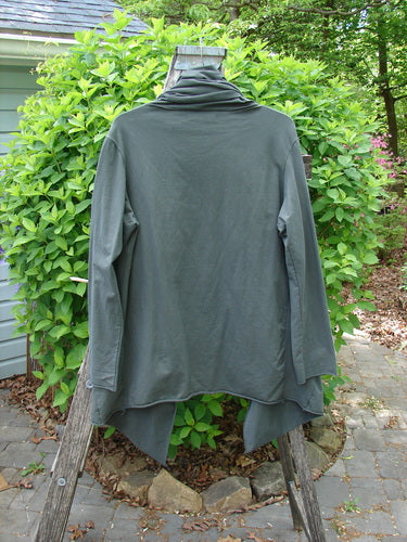 Barclay Cotton Lycra Gather Collar Open Front Jacket Unpainted Forest Size 1, featuring an oversized cowl neck, draped waterfall design, and unique drawcord neckline, displayed on a wooden ladder outdoors.