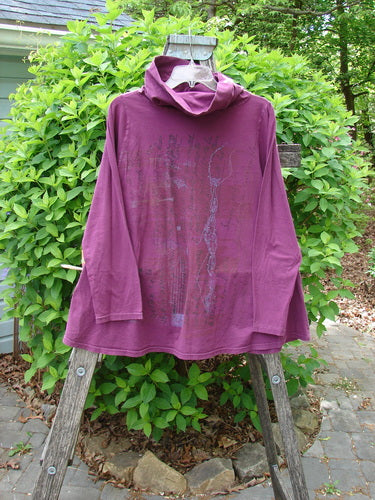 Barclay Cowl Neck Long Sleeved A Line Top Rock Note Merlot Size 0 displayed on a wooden stepladder, showcasing its double-layered cowl neckline, long sleeves, and sweet curly edgings against a natural outdoor backdrop.