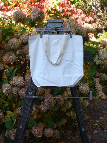 Barclay Canvas Promo Tote Bag Frenchtown Natural One Size displayed on an easel, features a short shoulder strap and spacious opening, reflecting Bluefishfinder.com's vintage and artistic essence.