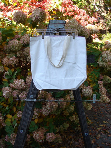 A white Barclay Promo Tote Bag with a shorter shoulder strap, generous top opening, and rounded bottom. Adorned with artwork celebrating Blue Fish Barclay Shops. Durable and perfect size.