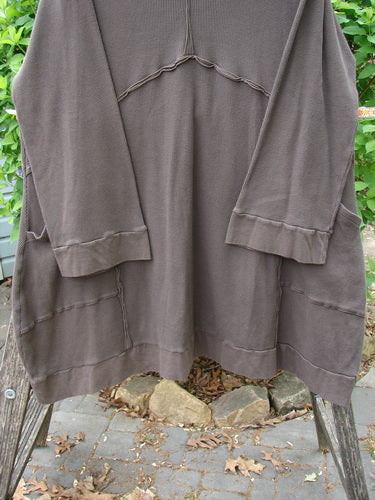 Barclay Patched Thermal Cowl Neck Reverse Stitch Pocket Pullover in Bark, displayed on a wooden frame outdoors, features decorative seams, cuffed sleeves, and a flared bottom, embodying BlueFishFinder's unique vintage style.