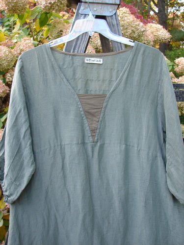 Barclay Hemp Silk Triangular Two Tier Dress displayed on a hanger, featuring a V-shaped neckline, pinched accents, and a garden-themed painted lower skirt.