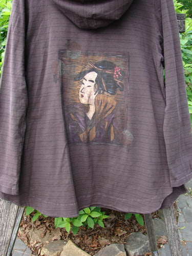 Barclay Cotton Lycra Twinkle Hoodie Pullover Geisha Stripe Bark Size 0 hanging on a bench, showcasing a Japanese-style portrait on its back, with garden elements subtly framing the scene.