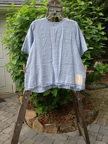 1999 Handkerchief Linen Camp Shirt Unpainted Stream Size 1 displayed on a wooden rack, showcasing its A-line shape, vented sides, and coordinating buttons.