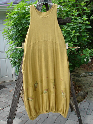 2000 Cotton Hemp Libby Jumper Falling Leaf Gold Altered Size 1 displayed on a clothesline, highlighting its sophisticated drape, downward scooped waistline, and extra bottom accented seam.