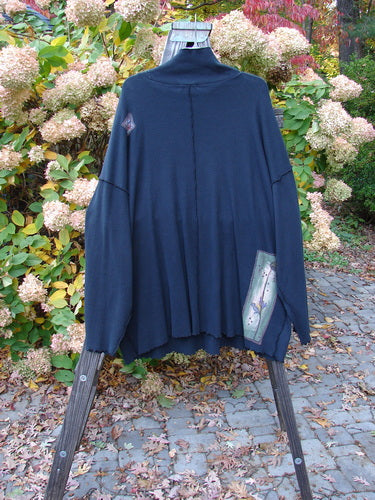 Barclay Patched Thermal Reverse Stitch Big Square Tunic with a floppy turtleneck and painted patches displayed on a stand, showcasing its unique drape, extra-long sleeves, and square boxy shape.
