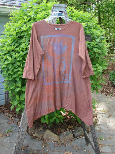 Barclay Three Quarter Sleeve Color Wheel Tunic Tulip Gourd Size 0, featuring a rust-brown tunic with three-quarter lettuce-edged sleeves and a faded flower motif, draped over a garden ladder.