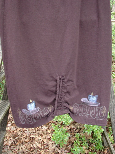 1999 Winter Skirt Candle Deep Burgundy Size 0, featuring a scooped front hemline, pegged lower shape, and candle-themed pattern, showcased outdoors on a grassy area.