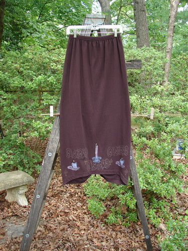 1999 Winter Skirt Candle Deep Burgundy Size 0 displayed on a ladder with its scooped front hemline and pegged lower shape, highlighting the tailored twist and drawcord back.