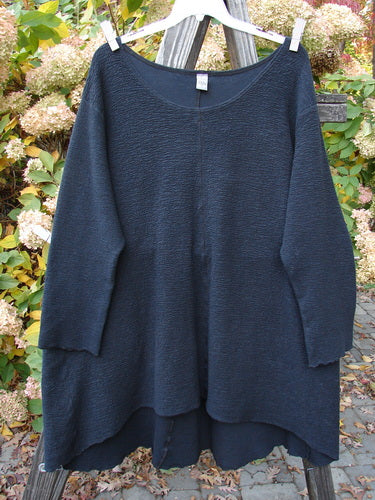 Barclay Crepe Hi Low Top Unpainted Black Size 2 displayed on a clothes rack, featuring a weighted textured stretch crepe fabric, wider rounded neckline, and long sleeves.