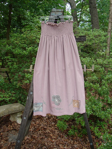 1995 Smocked Skirt Garden Patio Rose Size 2 displayed on a wooden ladder, showcasing its flowy full hip measurements and intricate 5-inch smocking, perfect vintage collectible from Bluefishfinder.com.