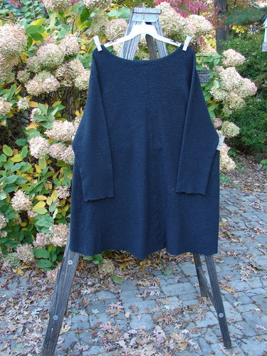 Barclay Crepe Hi Low Top Unpainted Black Size 2 displayed on a clothes rack, showcasing its textured stretch crepe fabric, wider rounded neckline, and long cozy sleeves.