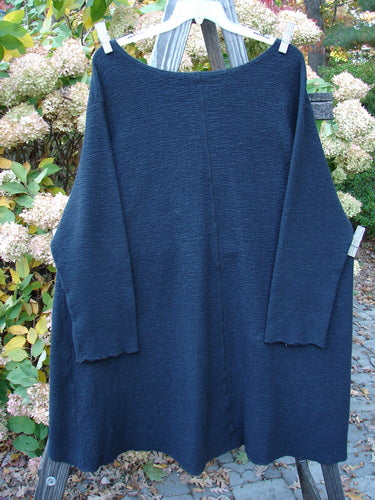 Barclay Crepe Hi Low Top Unpainted Black Size 2 hanging outdoors, showcasing its long cozy sleeves, wider rounded neckline, and upward curved front hemline.