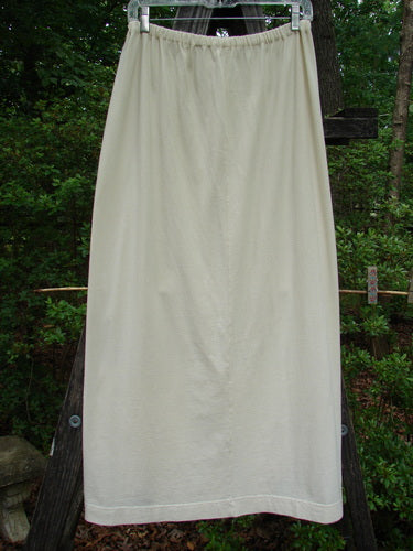 2001 Wishpocket Skirt Circle Rows Natural Size 1 hanging outdoors, showcasing its lightweight organic cotton fabric and unique circle rows design. Features front drawstring waist, oversized pockets, and vertical hem buttons.