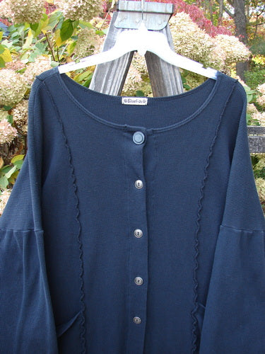 Barclay Thermal Curl Pocket Cardigan Unpainted Black Size 3 displayed on a hanger, featuring a full button front, dolman sleeves, two front pockets, and a slightly curved hemline.