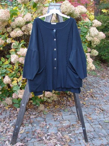 Barclay Thermal Curl Pocket Cardigan on a wooden stand, showcasing its dolman sleeves, button front, and exterior pockets.