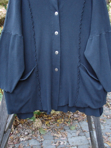 Barclay Thermal Curl Pocket Cardigan Unpainted Black Size 3, featuring a full button front, dolman sleeves, two drop front pockets, and a wider neckline, showcased on a person outdoors.