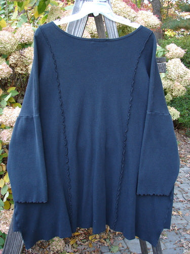 Barclay Thermal Curl Pocket Cardigan Unpainted Black Size 3 displayed on a clothes rack, showcasing its button front, dolman sleeves, and exterior pockets, embodying vintage Blue Fish Clothing's unique style.
