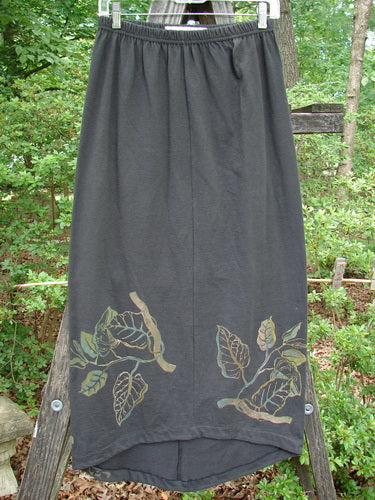 1998 Botanicals Corolla Skirt Leaf Vine Raven Size 1 from Spring Botanicals Collection, featuring an upward scooped front hemline and leaf vine design. Full elastic waistband, pocketless, organic cotton, slenderizing fit.