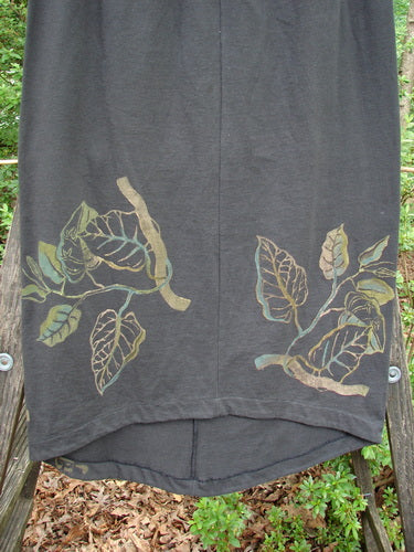 1998 Botanicals Corolla Skirt Leaf Vine Raven Size 1: A black skirt with painted leaf designs, featuring a full elastic waistband and an upward scooped front hemline. No pockets.