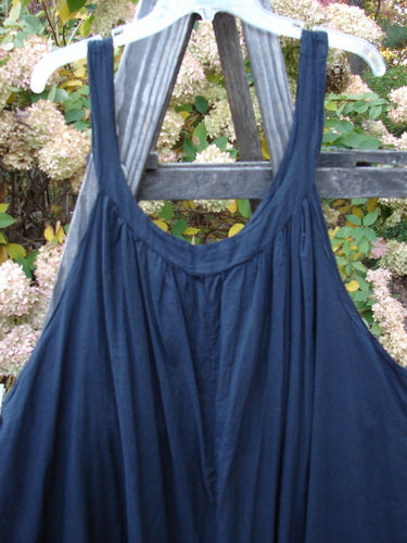 Barclay Batiste Banded Collar Slip Dress on a wooden rack, featuring a deep rounded neckline, wide shoulder straps, and a swingy lower.