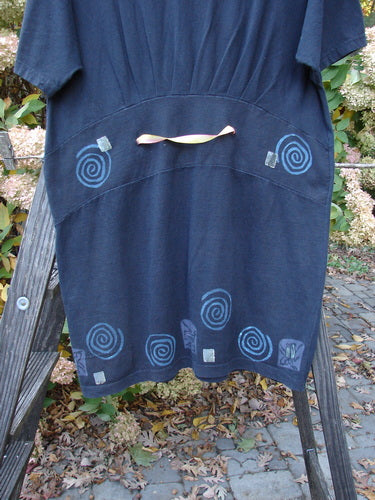 1992 Little Storma Dress Garden Bug Black Small OSFA displayed on a wooden ladder, featuring a spiral pattern and intricate detailing, including a deep rounded neckline and gathered top rear with two slits.