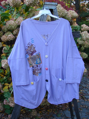 1997 Day Jacket Silly Pup Freesia Size 3 on a clothes rack, featuring vintage buttons, two front pockets, dolman sleeves, V neckline, rounded tails, and a painted cartoon design.