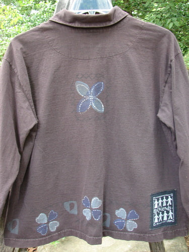 1999 Hidden Pocket Jacket Clover Heart Current Size 0, featuring a slight A-line shape, drop shoulders, oversized blue buttons with clover heart design, bright signature patch, and hidden pocket.