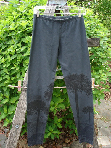 Barclay Cotton Lycra Relaxed Legging Shadow Tree Lux Silhouette Size 0, featuring a subtle tree-silhouette print on dark-gray fabric, displayed on a hanger over a wooden ladder.