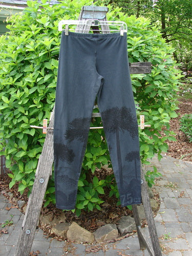 Barclay Cotton Lycra Relaxed Legging Shadow Tree Lux Silhouette Size 0, draped over a wooden A-frame outdoors. Features full elastic waistband, wide lowers, and shadow tree paint, capturing a relaxed elegance.