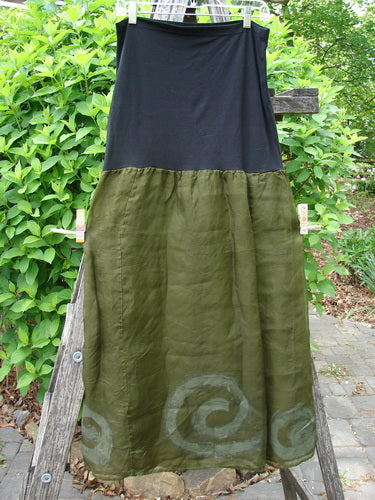 2000 Silk Organza Aios Dana Skirt Celtic Lichen Size 1 displayed outdoors; features a black upper and olive green lower with a spiral-patterned hem.