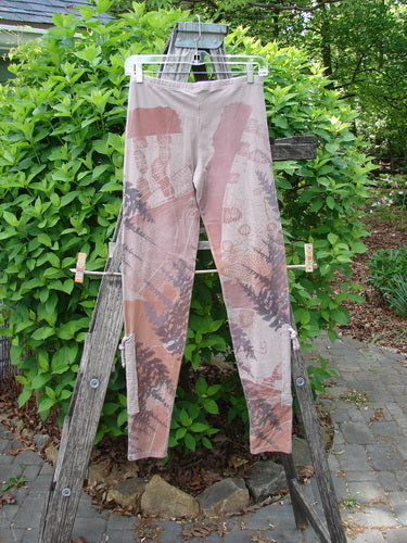 Barclay Cotton Lycra Side Gather Legging Forest Moon Oriel Size 0 features abstract earth-tone fern print, slim fit, elastic waistband, and exterior drawcords, hanging outdoors on a wooden ladder in a garden.