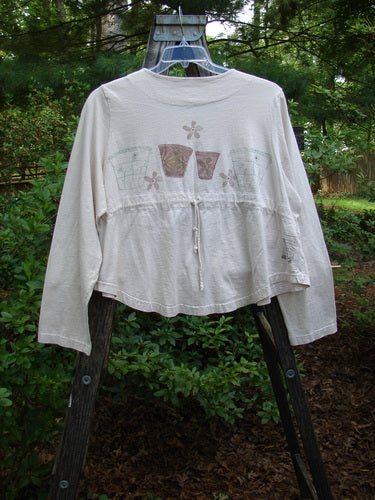 1999 Coffee Top Flowerpot Tea Dye Size 1 on a swinger, featuring a rounded hemline, big button closures, and drawcord back with a classic flowerpot design, from Blue Fish's Spring Collection.