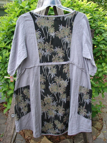 Barclay Linen Pucker Heart and Soul Dress Tropical Black Grey Size 0 features a light gray linen with black palm motif panels, dropped waist, and flared hem, displayed outdoors against foliage.