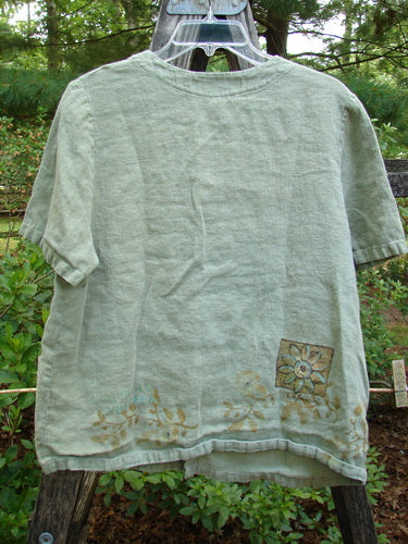 1998 Botanicals Robin's Top Daisy Elm Size 0 displayed on a clothesline, showcasing its A-line shape, dual front pockets, and seven tiny buttons, highlighting the vintage charm and meticulous craftsmanship.