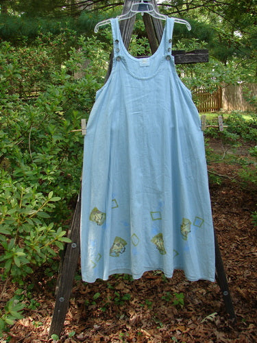 2000 Strappy Jumper Leaf Path Blue Jet Size 1 displayed on a wooden stand, featuring thick pearl buttons, a feminine scooped neckline, and a flared A-line shape with leaf-themed hemline details.