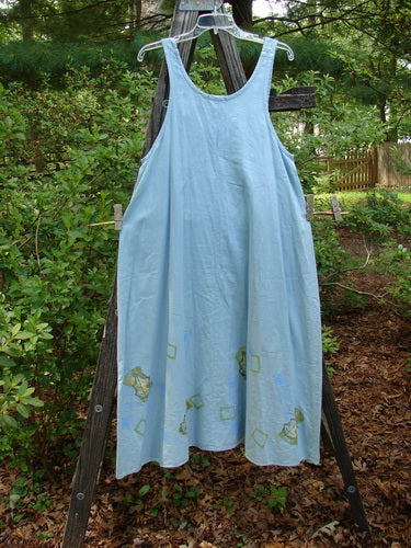 2000 Strappy Jumper Leaf Path Blue Jet Size 1 displayed on a wooden ladder, showcasing its A-line flare, pearl button adjustments, and bright leaf path hemline.