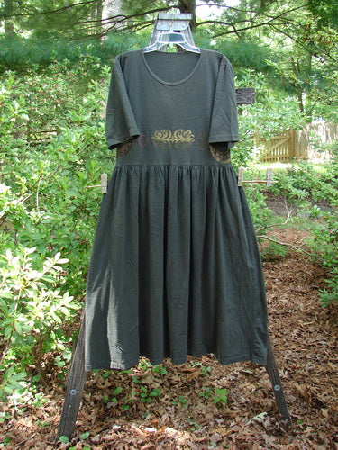 1992 Short Sleeved Simple Dress Metallic Black Sand Altered Size 1 displayed on a clothesline outdoors, highlighting its semi-dropped waistline, full draping lower, and signature Blue Fish Patch.