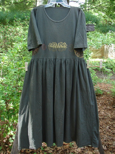 1992 Short Sleeved Simple Dress Metallic Black Sand Altered Size 1 hanging on a clothesline, showcasing its semi-dropped, gathered waistline and full draping lower with the Blue Fish Patch visible.