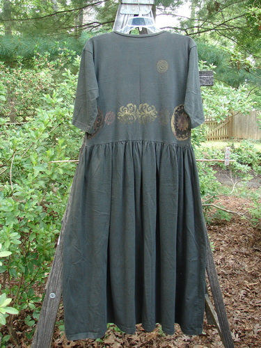 1992 Short Sleeved Simple Dress Metallic Black Sand Altered Size 1 displayed on a hanger, featuring a semi-dropped waistline, full draping lower, and a deeper rounded neckline.