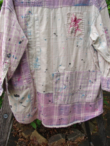 Magnolia Pearl Flannel Patched Surfside Shirt Sun Bleached OSFA hangs outdoors, showcasing off-white and pale purple plaid sections with paint splatters, patch pockets, and a frayed hem, embodying artistic flair.