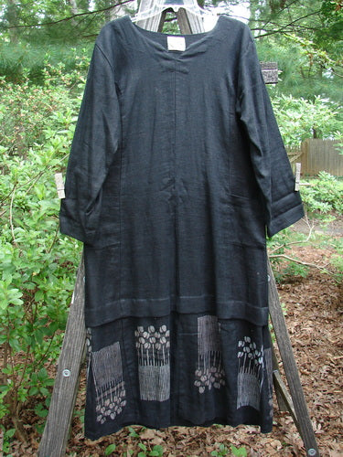 Black 2000 Ringlet Dress Tulip Grass Altered Size 1, on a wooden stand, features sectional panels, oversized pockets, a V-shaped neckline, double drawcord back, and daisy-themed hem.