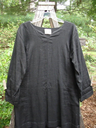 2000 Ringlet Dress Tulip Grass Black Altered Size 1 on a clothes rack, showcasing oversized pockets, V-shaped neckline, and daisy-themed hem in superior linen.