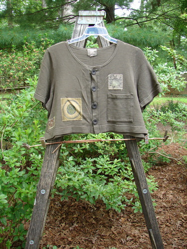 2000 Patched Recycle Jacket Science Bark Size 0 displayed on a wooden ladder, featuring a feminine rounded neckline, flared hemline, square drop pocket, and various colorful bio-themed patches.